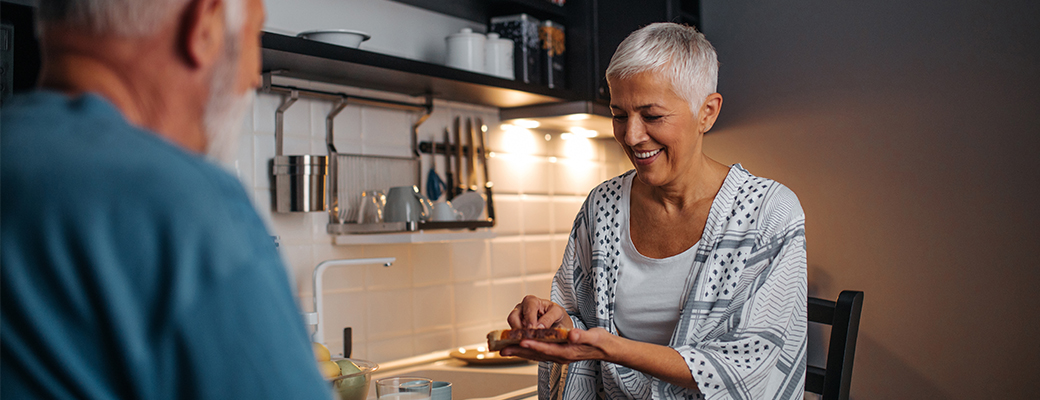 Image of a senior woman showing senior husband some ingredients in the kitchen